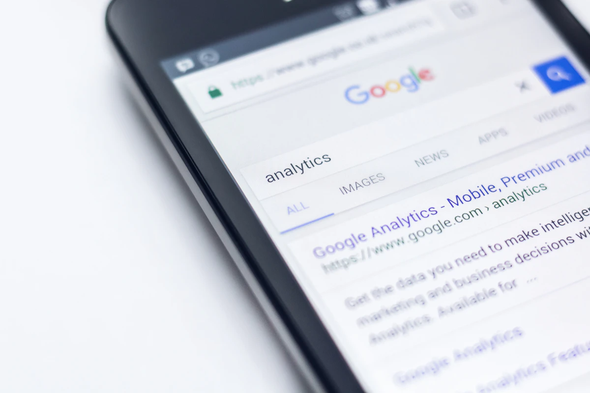 Telemóvel pousado numa mesa branca com resultados de pesquisa da Google abertos no ecrã