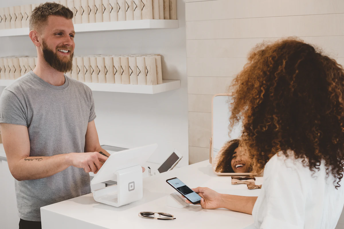 Cliente a pagar com o telemóvel ao balcão de uma loja