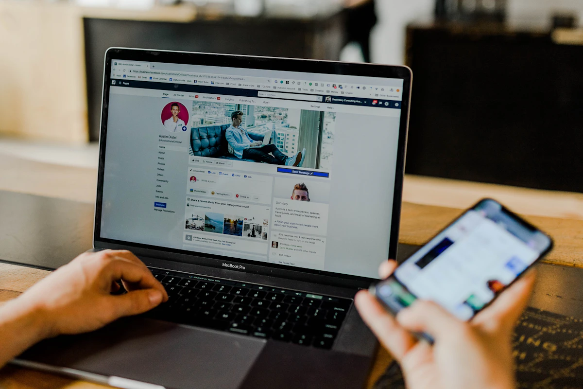 Pessoa a usar o Facebook no portátil e no telemóvel ao mesmo tempo
