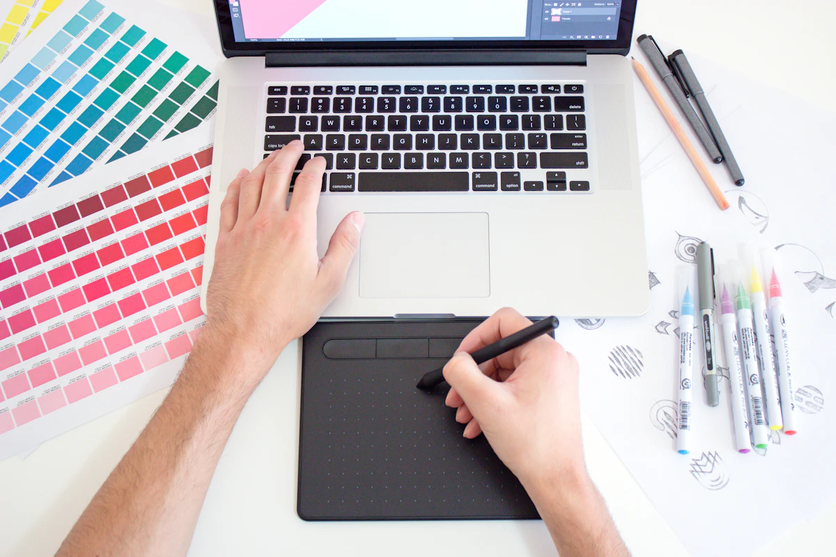 Designer a comparar amostras de cores em leque sobre uma mesa de trabalho
