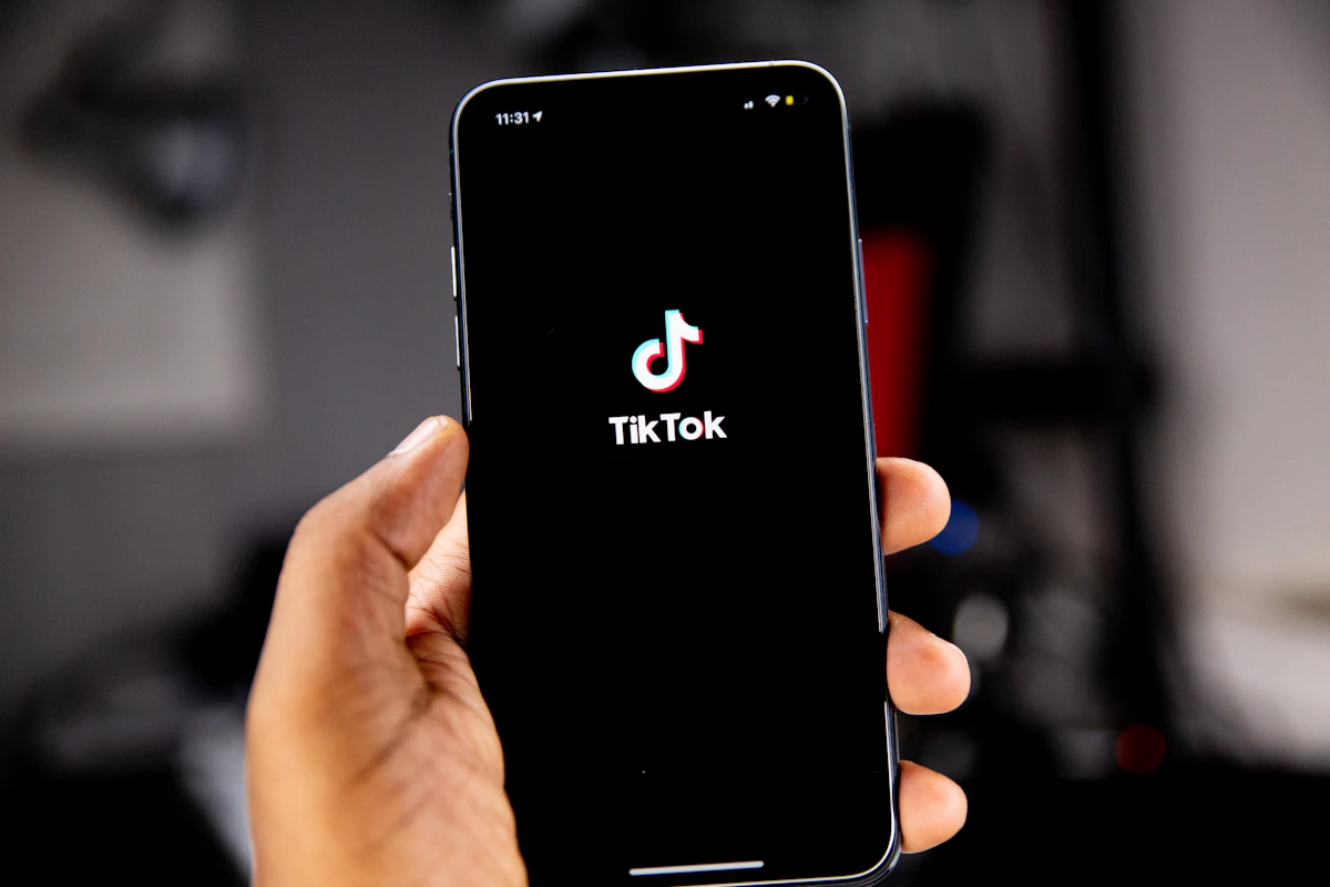 Mão a segurar um telemóvel com o logótipo do TikTok no ecrã