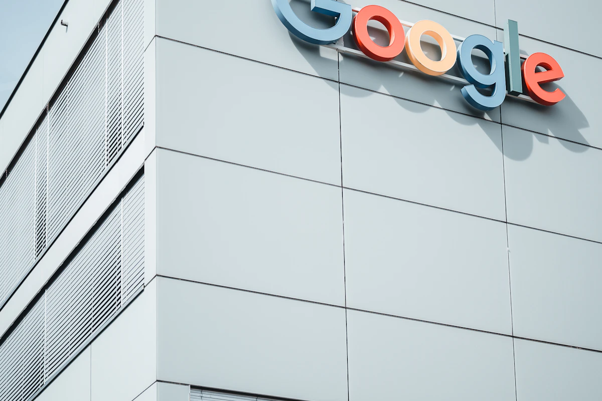 Logótipo colorido da Google no topo de um edifício branco, visto de baixo