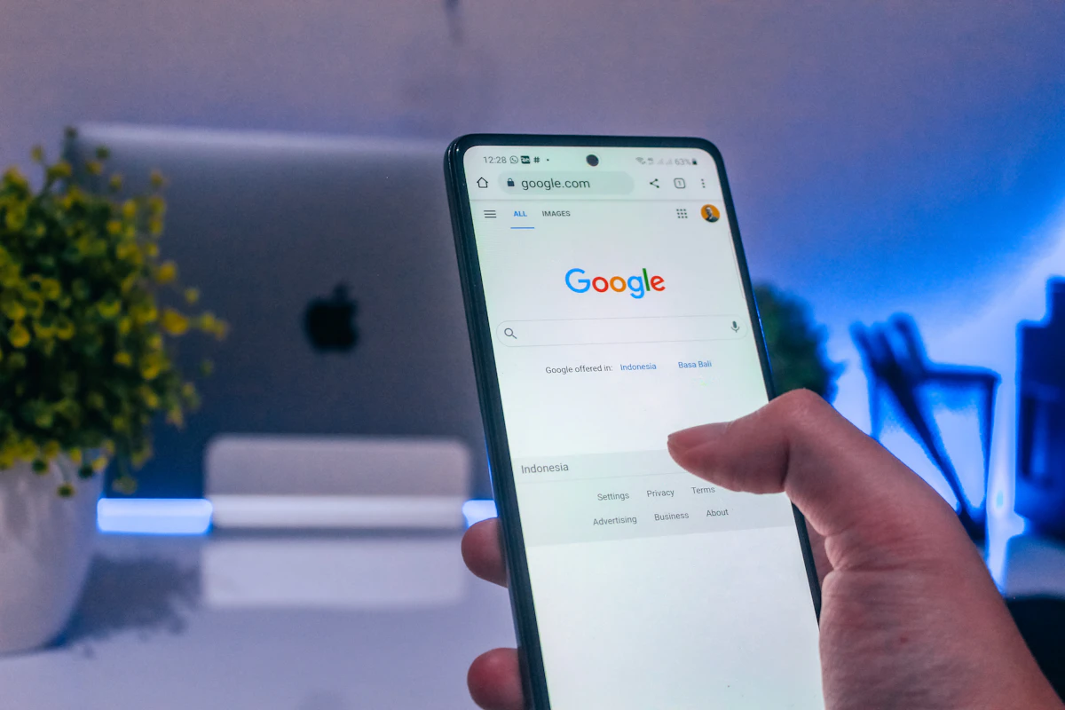 Mão a segurar um telemóvel com a página de pesquisa do Google aberta