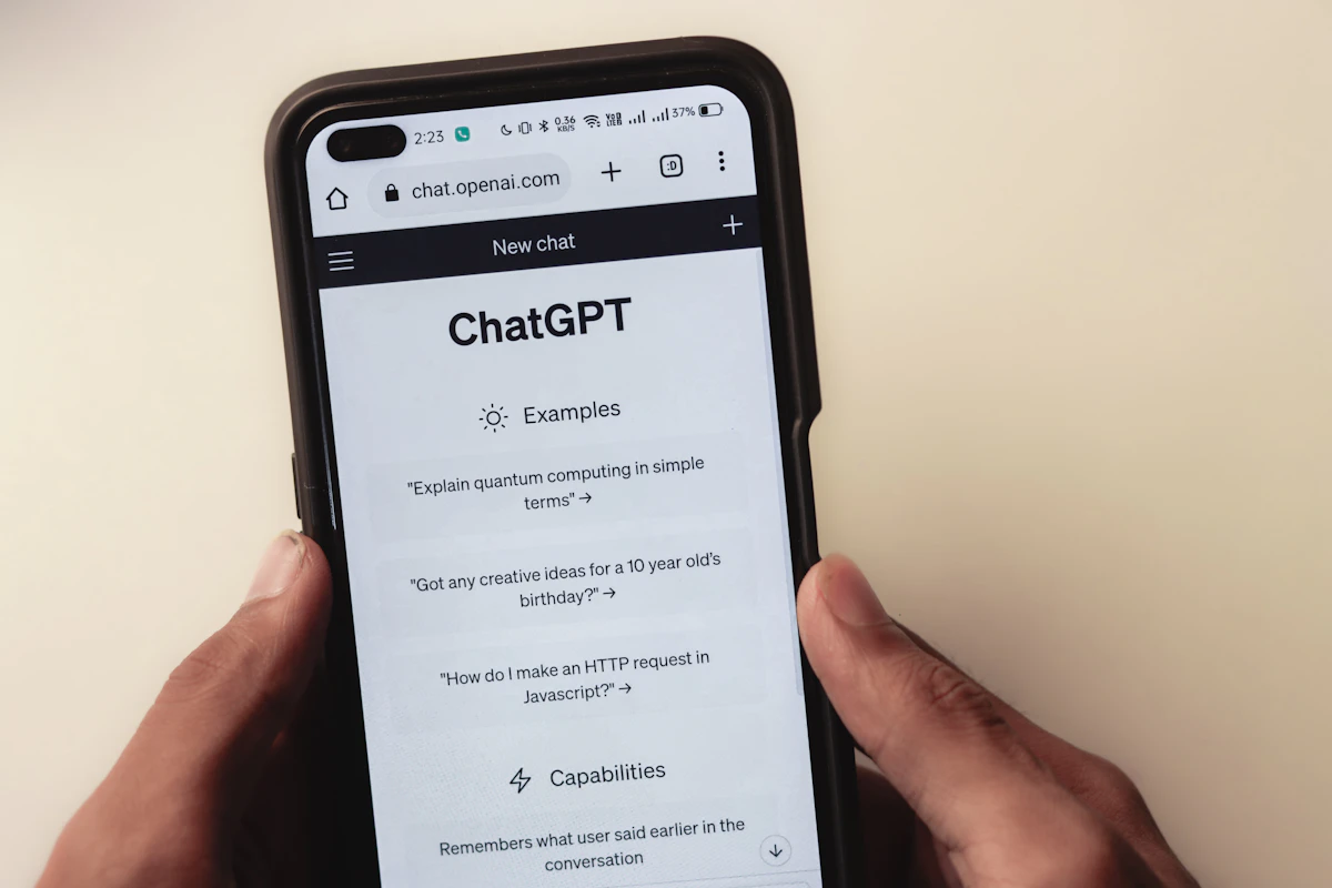 Mãos a segurar um telemóvel com uma conversa num chatbot de IA