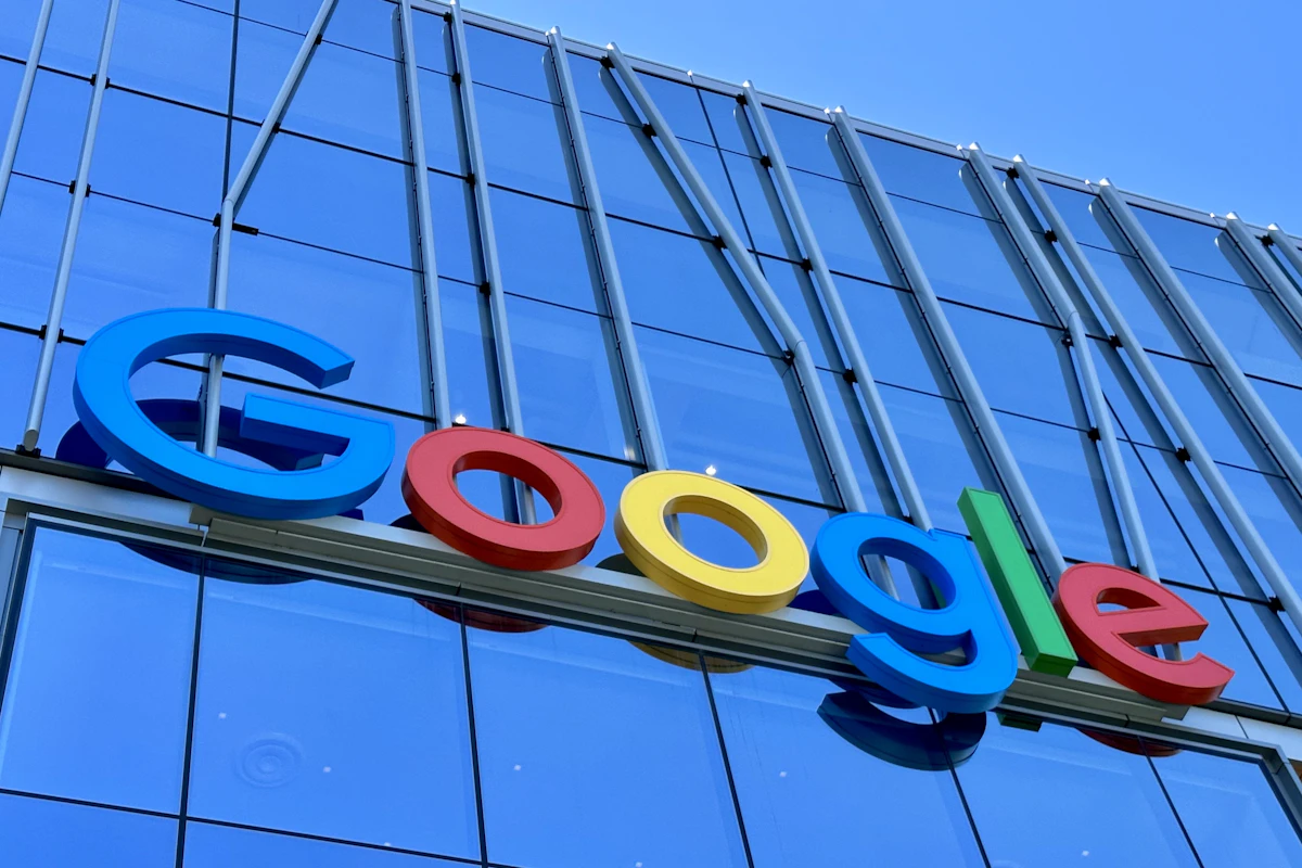 Logótipo colorido da Google na fachada de vidro azul de um edifício de escritórios