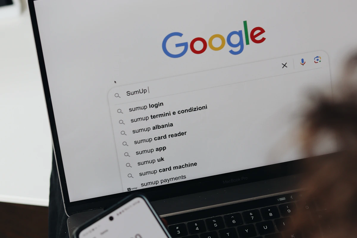 Portátil com a página de pesquisa da Google aberta e sugestões de pesquisa no ecrã