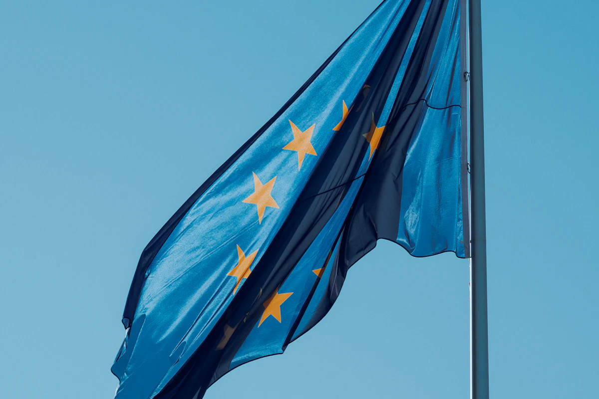 Bandeira da União Europeia a esvoaçar contra o céu azul