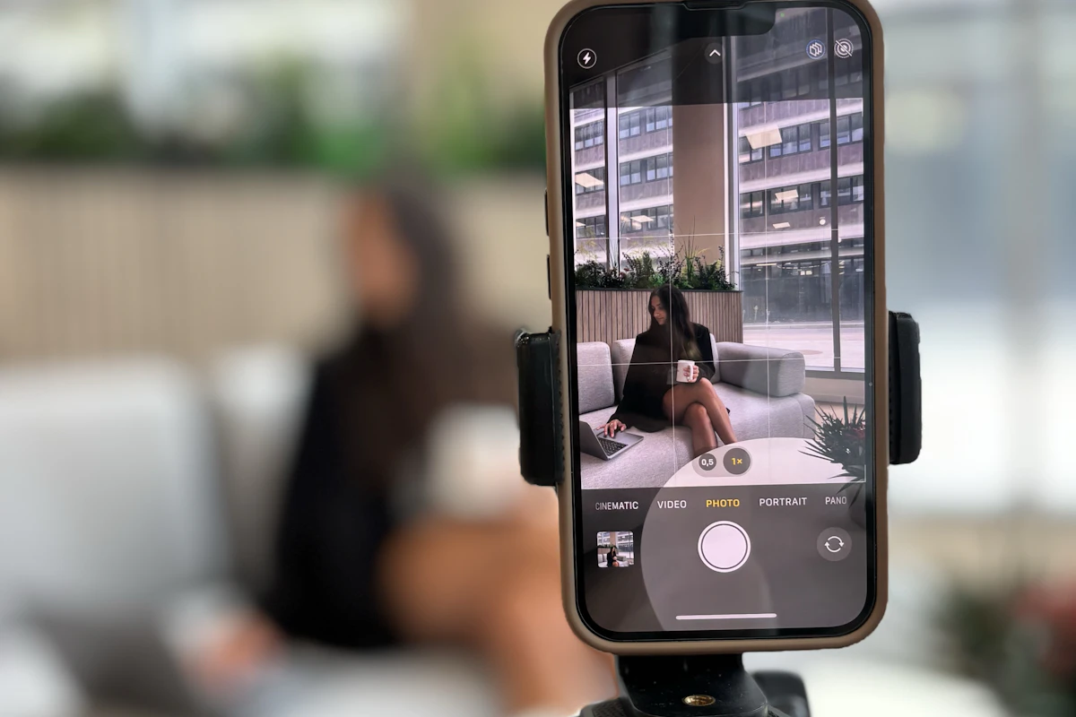 Telemóvel num tripé a gravar uma pessoa sentada num sofá
