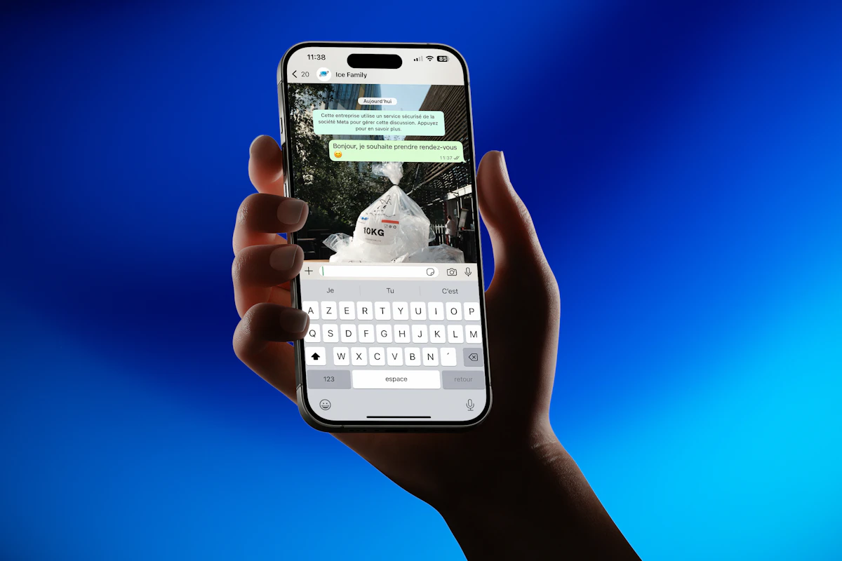 Mão a segurar um telemóvel com uma conversa aberta numa app de mensagens