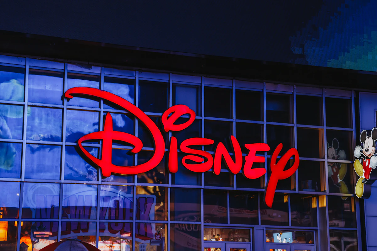 Fachada de uma loja Disney à noite, com o logótipo vermelho iluminado sobre a montra