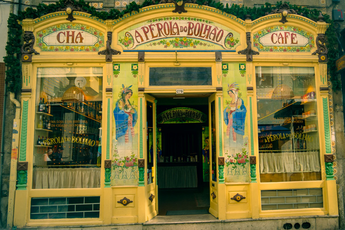 Fachada amarela e decorada da loja A Pérola do Bolhão, no Porto, com as palavras Chá e Café