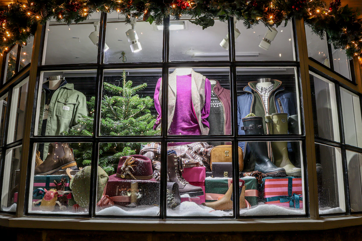 Montra de loja decorada para o Natal com manequins de inverno e uma pequena árvore